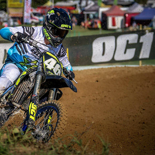 Motocross-Fahrer in der Kurve an einer OC1-Bande