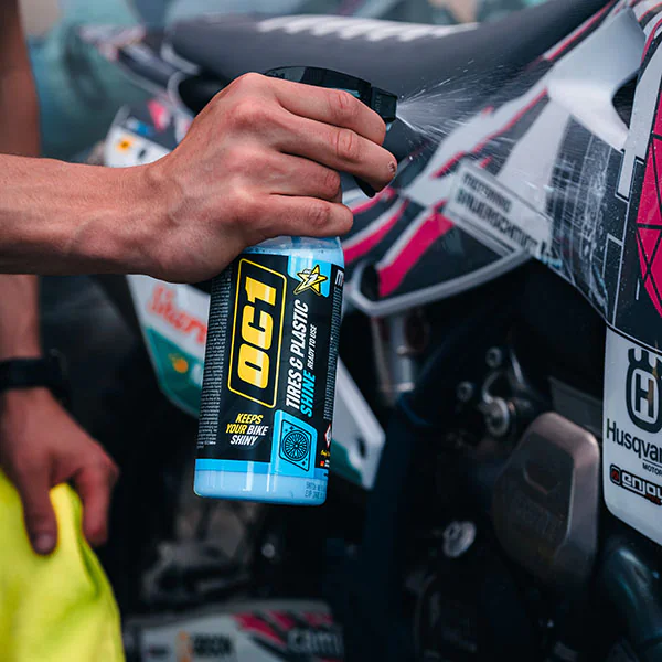 Auftragen des OC1 Tires & Plastic Shine auf die Kunststoffteile eines Motorrads im professionellen Service
