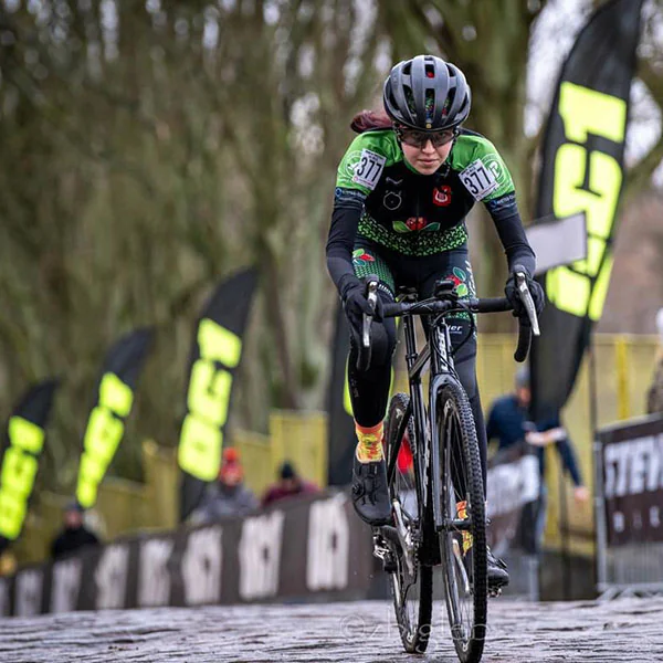 Cyclocross-Rennen auf nassem Kopfsteinpflaster vor OC1-Flaggen